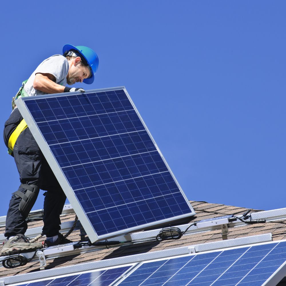 Radnik na krovu drži postavlja solarni panel
