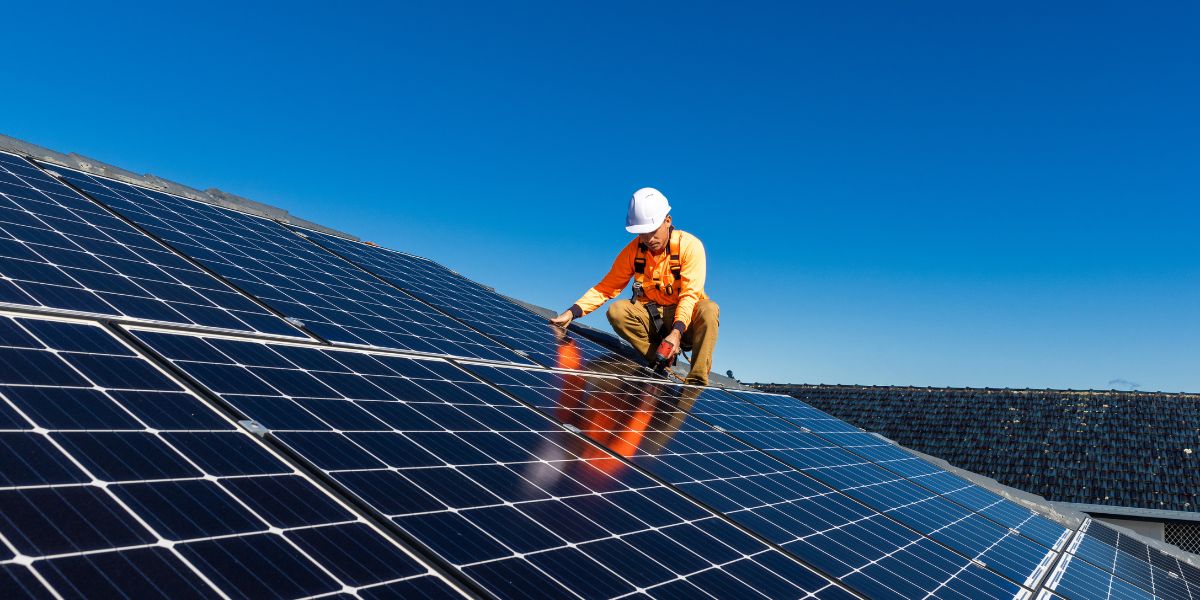 Radnik na krovu sa solarnim panelima